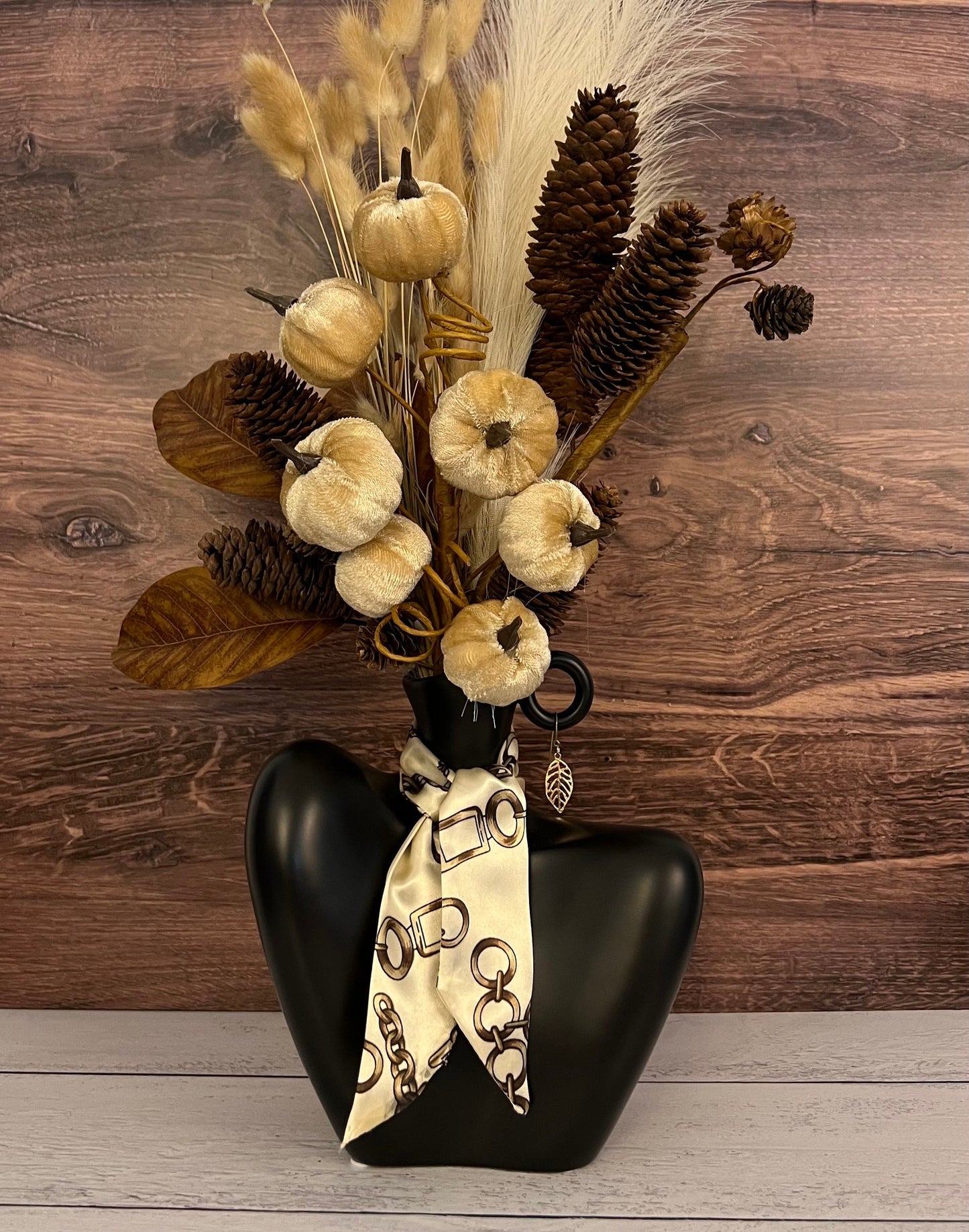 Artificial floral arrangement in a vase. Ceramic centerpiece with faux flowers, and velvet pumpkins. Faux floral arrangement for home decor.